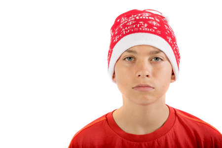 Sad caucasian teenage boy wearing a Christmas hat, isolated on white background