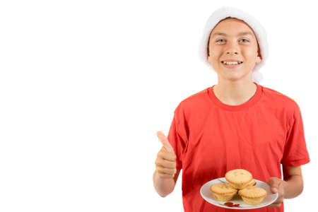 Teenage boy with a plate of mince pies giving positive gesturesの写真素材