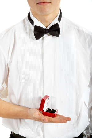 18 year old wearing a tuxedo holding a ring box isolated on a white backgroundの写真素材