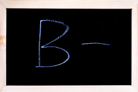 Blackboard with white chalk writing showing grade B-