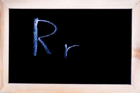 Blackboard with white chalk writing showing capital and lowercase Rの写真素材