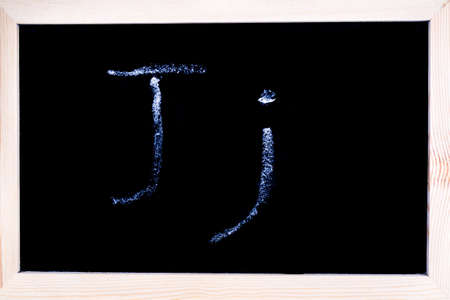 Blackboard with white chalk writing showing capital and lowercase Jの写真素材
