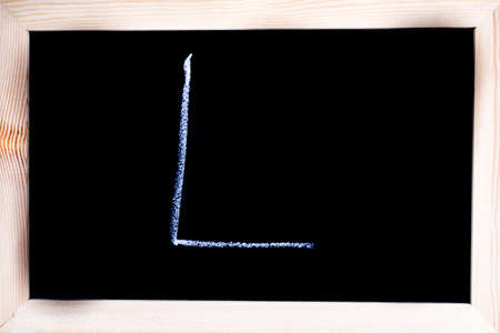 Blackboard with white chalk writing showing capital letter Lの写真素材