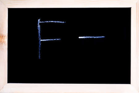 Blackboard with white chalk writing showing grade F-の写真素材