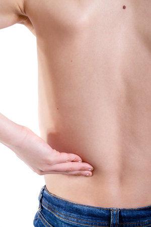 Young caucasian teenage boy with pains in his lower back