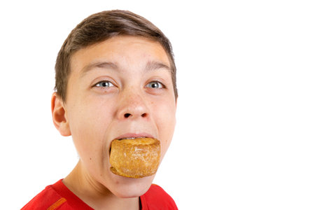 Young caucasian teenage boy eating a pork pie