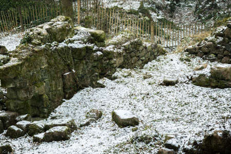 The ruins of an old stone watermill on Dartmoor, United Kingdom. The ruins have a light dusting of snow from the start of the Beast From The East winter storm of 2018の写真素材