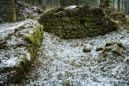 The ruins of an old stone watermill on Dartmoor, United Kingdom. The ruins have a light dusting of snow from the start of the Beast From The East winter storm of 2018の写真素材