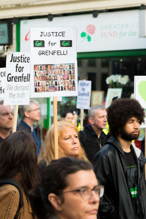 London, United Kingdom, 14th April 2018:- Marchers on a silent march from Kensington Town Hall to the ruins of Grenfell tower ten months on from the devastating fire that killed 71のeditorial素材