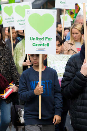 London, United Kingdom, 14th April 2018:- Marchers on a silent march from Kensington Town Hall to the ruins of Grenfell tower ten months on from the devastating fire that killed 71のeditorial素材