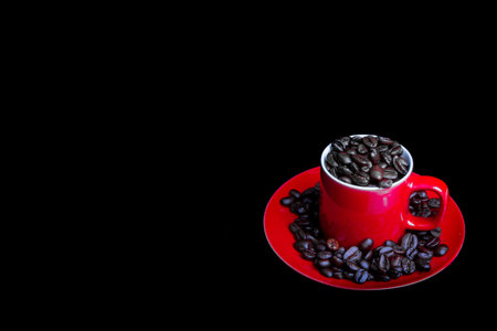 Whole roasted coffee beans and a coffee mug