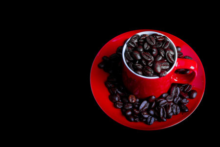 Whole roasted coffee beans and a coffee mug