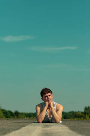 Young adult male laying outside in the sunshineの写真素材