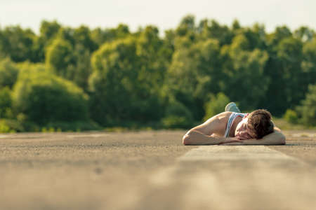Young adult male laying outside in the sunshineの写真素材
