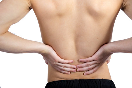 Fit shirtless caucasian young adult with lower back pain