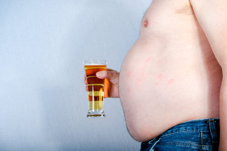 Overweight shirtless caucasian man holding a beer