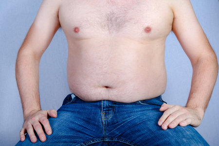 Overweight shirtless caucasian man sitting down