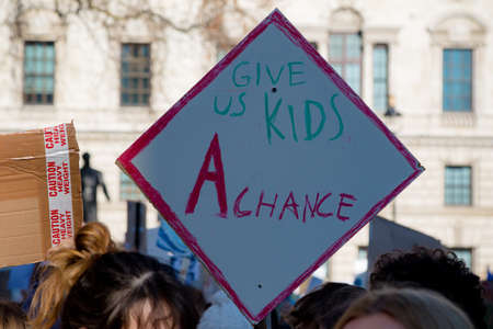 London, UK, United Kingdom 15th February 2019:- Striking school aged children in central London over climate change holding a placardのeditorial素材