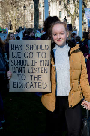 London, UK, United Kingdom 15th February 2019:- Striking school aged children in central London over climate change holding a placardのeditorial素材
