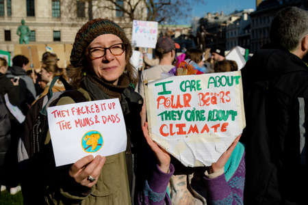 London, UK, United Kingdom 15th February 2019:- Striking school aged children and an adult in central London over climate change holding a placardsのeditorial素材