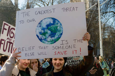 London, UK, United Kingdom 15th February 2019:- Striking school aged children in central London over climate change holding a placardのeditorial素材
