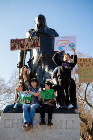 London, UK, United Kingdom 15th February 2019:- Striking school aged children in central London over climate change sit on the plith of the Winston Churchill statue in Parliament Squareのeditorial素材