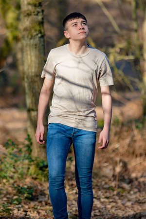 Teenage caucasian boy walking through woodland on a warm spring dayの写真素材