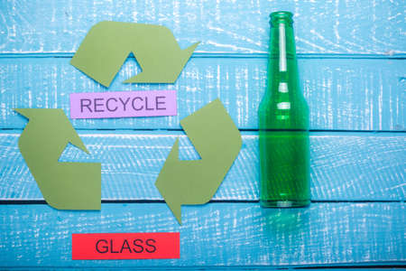 Recycle concept showing the green recycle logo with glass & recycle on a blue weathered backgroundの写真素材