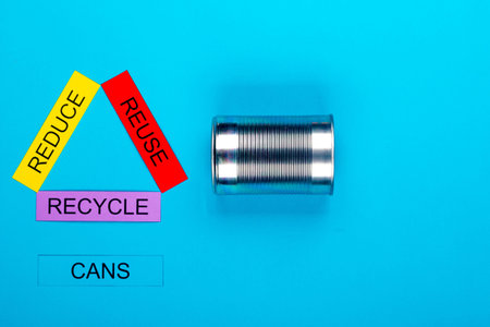 Recycle concept showing reduce, reuse & recycle with cans on a blue background