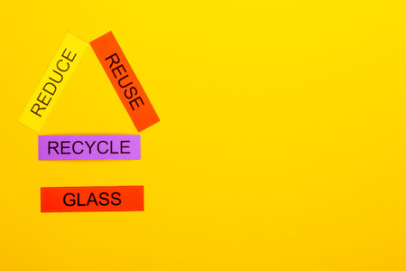 Recycling concept showing reduce, reuse & recycle with glass on a yellow background