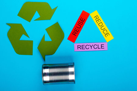 Recycle concept showing the green recycle logo with reduce, reuse, recycle & cans on a blue...