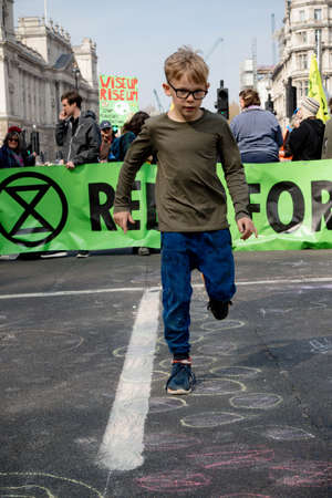 London, United Kingdom, 15th April 2019:- Extinction Rebellion child protester in Parliament Square, plays hop scotch protesting about climate change.のeditorial素材