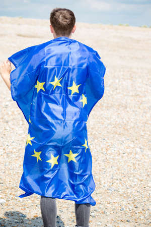 Young adult caucasian male holding on a beach holding the flag of the European Unionの写真素材