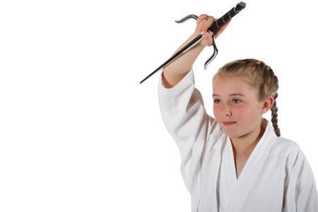 Pre-teen caucasian girl wearing a karate uniform using Sai