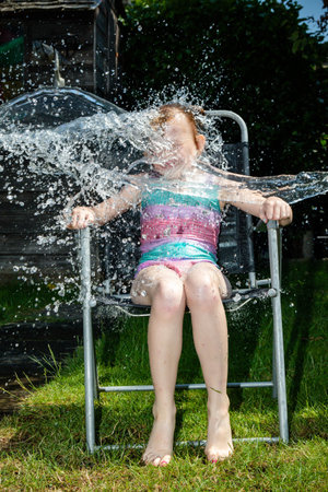 Preteen caucasian girl being splashed with waterの写真素材