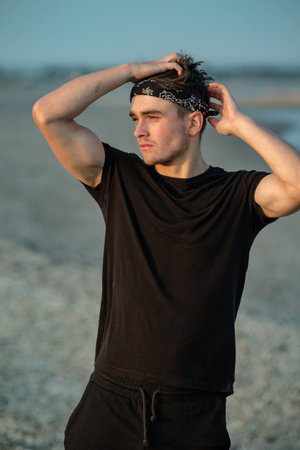 Young male adult portrait at golden hour on a beach