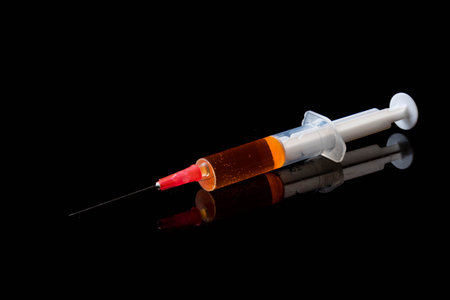 Illegal drug crisis concept showing a full syringe on a black background