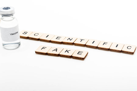 Vaccine concept showing a medical vial with a Vaccine label on a white background along with a sign...