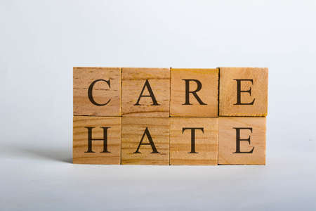 Wooden cubes with lettering spelling Care Hate. Concept that Care beats Hateの写真素材