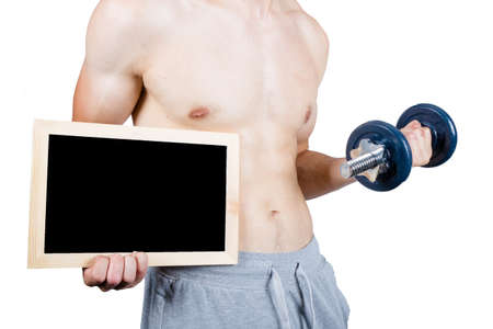 Weight losee concept showing a muscular young male adult wearing a tracksuit holding a blackboard and dumbbellの写真素材