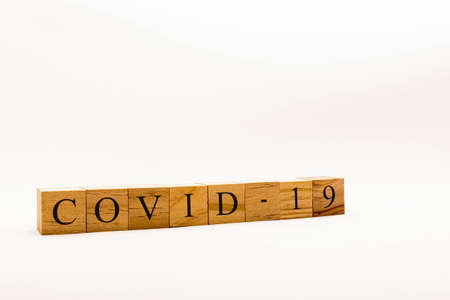 Coronavirus concept showing wooden blocks on a white background reading Covid-19の写真素材