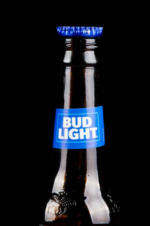 Sandhurst, United Kingdom; February 16th 2021:- A close up of an open bottle of Bud Light with a bottle top on the lip, isolated on a black backgroundのeditorial素材