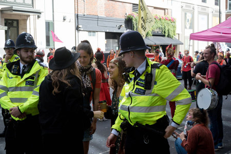 London, United Kingdom, 21st August 2021:- Members of Extinction Rebellion talk through police lines...