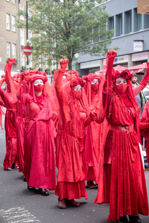 London, United Kingdom, 21st August 2021:- Extinction Rebellion protesters dressed in red march...