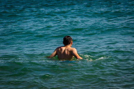 A 18 year old Caucasian shirtless teenage boy in swimwear in the seaの写真素材