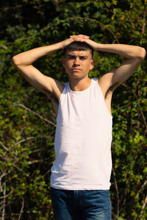 An 18 year old teen boy in a sleeveless top on a late summer's dayの写真素材