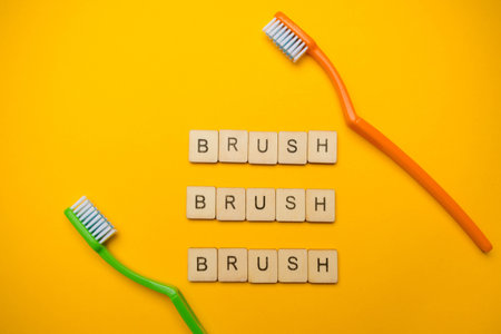 Oral and dental health concept showing two toothbrushes and a sign reading Brush Brush Brush on a...