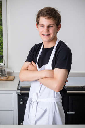 A portait of a teenage boy in a domestic kitchenの写真素材