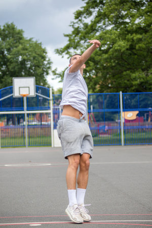 A Nineteen Year Old Teenage Boy Shooting A Hoop in A Basketball Court in A Public Park