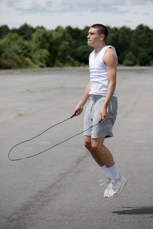 A Nineteen Year Old Teenage Boy Using A Skipping Rope in A Public Parkの写真素材